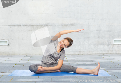 Image of happy woman making yoga and stretching on mat