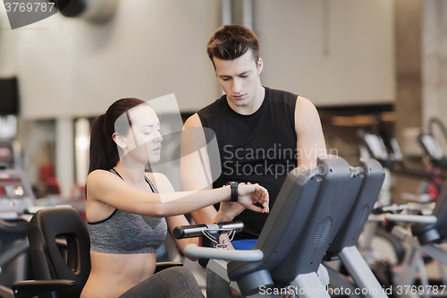 Image of woman with trainer on exercise bike in gym