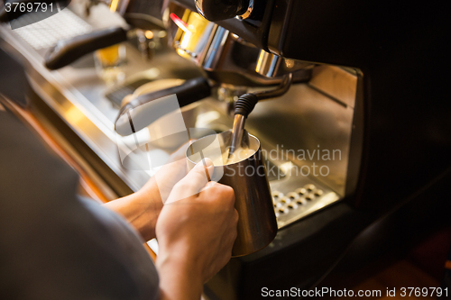 Image of close up of woman making coffee by machine at cafe