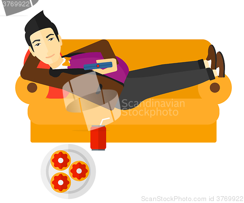 Image of Man lying on sofa with junk food.