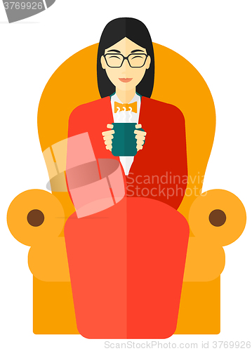 Image of Woman sitting in chair with cup of tea.