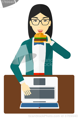 Image of Woman eating hamburger. 