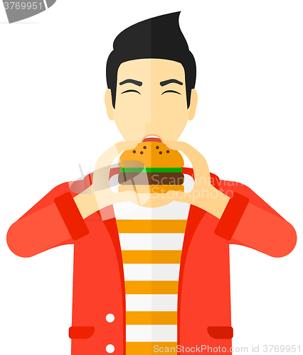 Image of Man eating hamburger. 