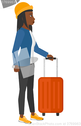 Image of Woman standing with suitcase.