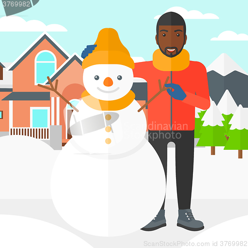 Image of Man posing near snowman.