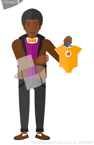 Image of Man holding clothes for baby.