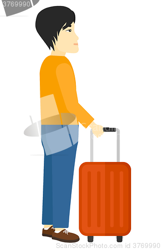 Image of Man standing with suitcase.