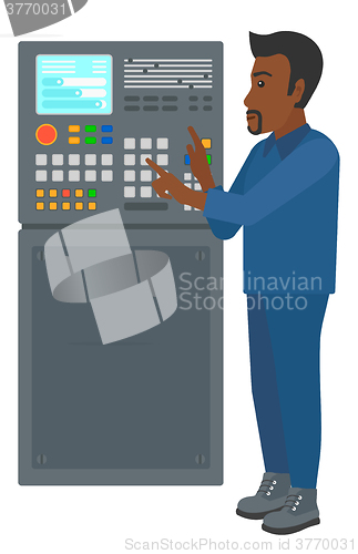 Image of Engineer standing near control panel.