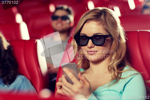 Image of happy woman with smartphone in 3d movie theater