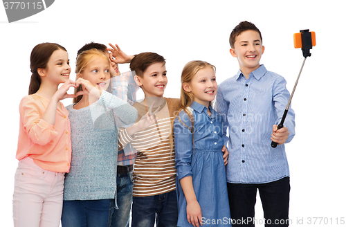 Image of happy children with smartphone and selfie stick