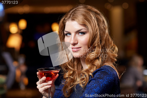 Image of glamorous woman with cocktail at night club or bar