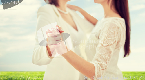 Image of close up of happy married lesbian couple dancing