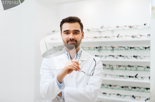 Image of man optician with glasses in coat at optics store