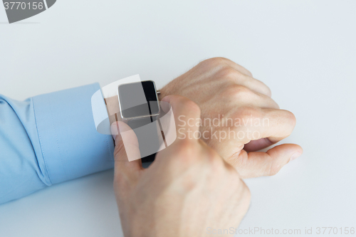 Image of close up of male hands setting smart watch