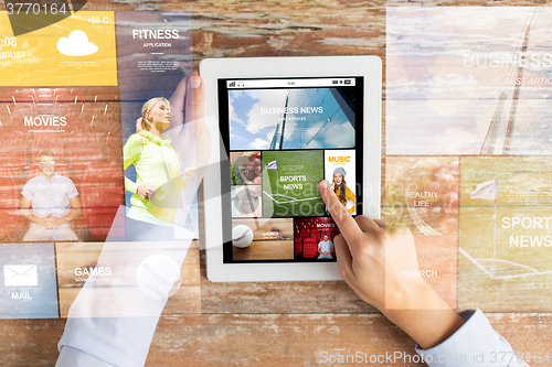 Image of close up of hands with news app on tablet pc