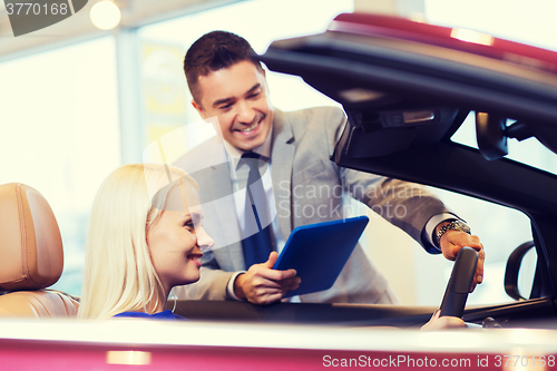 Image of happy woman with car dealer in auto show or salon