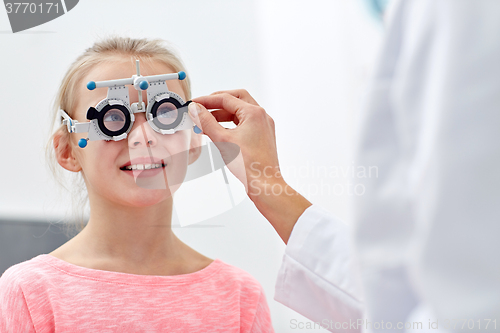 Image of optician with trial frame and girl at clinic