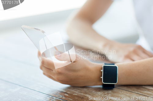 Image of close up of hands with smart phone and watch