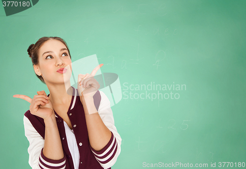 Image of happy teenage student girl over green school board