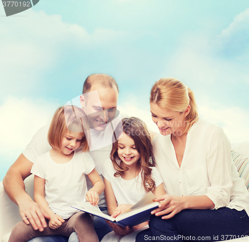 Image of happy family with book at home