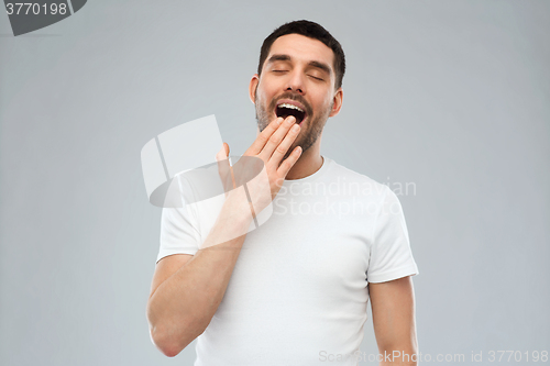 Image of yawning man over gray background