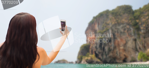 Image of young woman taking selfie with smartphone