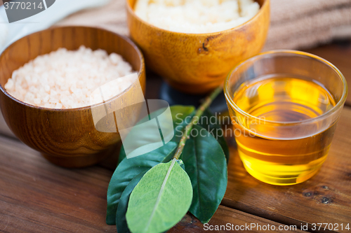 Image of close up of honey in glass with pink salt on wood