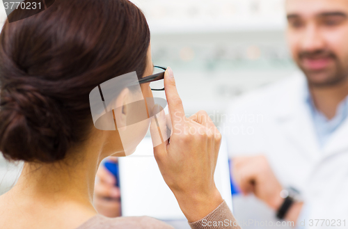 Image of close up of woman choosing glasses at optics store