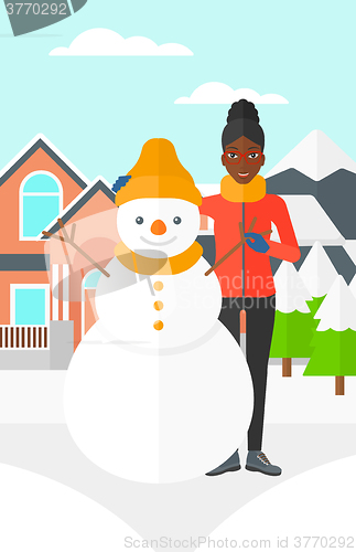 Image of Woman posing near snowman.