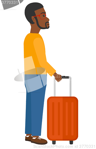 Image of Man standing with suitcase.