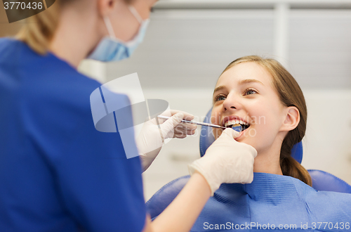 Image of female dentist checking patient girl teeth