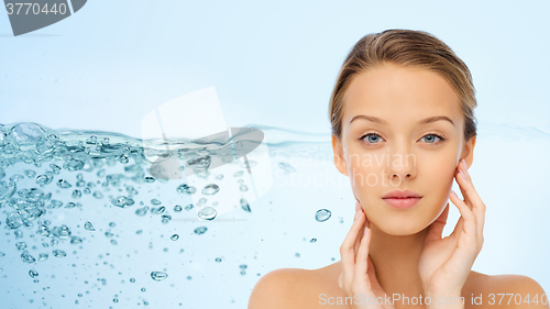 Image of young woman touching her face