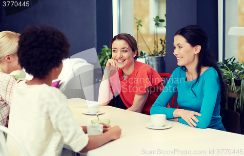 Image of happy young women drinking tea or coffee at cafe