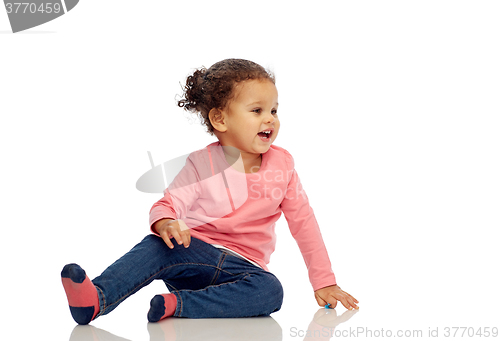 Image of smiling little baby girl sitting on floor