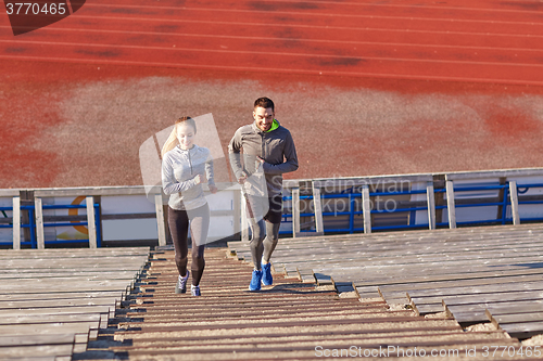 Image of happy couple running upstairs on stadium