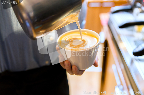 Image of close up of woman making coffee at shop or cafe