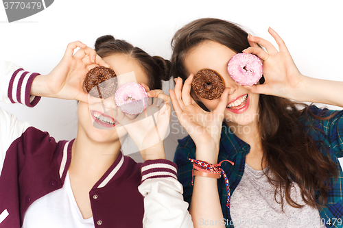 Image of happy pretty teenage girls with donuts having fun