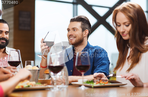 Image of friends dining and drinking wine at restaurant