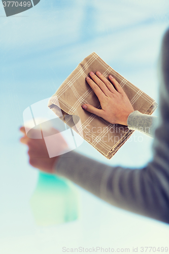 Image of close up of woman hands cleaning window with cloth