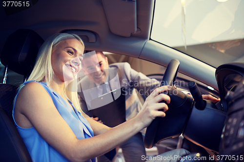 Image of happy woman with car dealer in auto show or salon