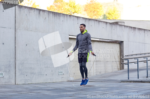 Image of man exercising with jump-rope outdoors