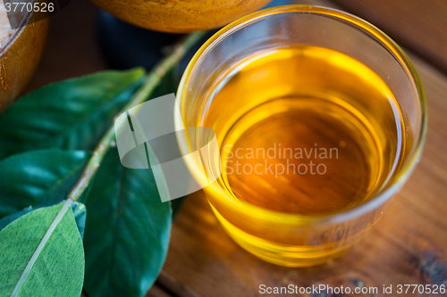 Image of close up of honey in glass with leaves on wood