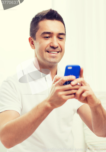 Image of happy man with smartphone at home