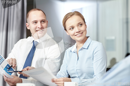 Image of business people with papers meeting in office