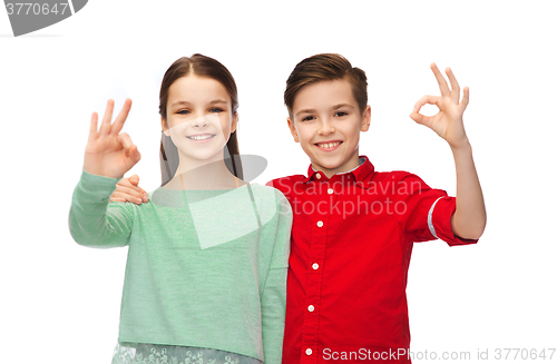 Image of happy boy and girl showing ok hand sign