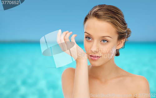 Image of woman smelling perfume from wrist of her hand