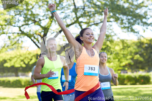 Image of happy young female runner winning on race finish