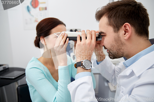 Image of optician with pupilometer and patient at eye clinic