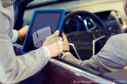 Image of close up of men with tablet pc in car salon