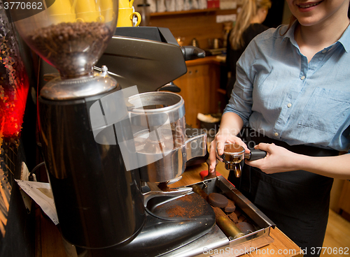 Image of close up of woman making coffee by machine at cafe